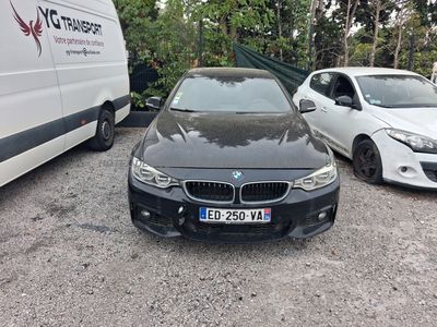 a black bmw car parked in a lot next to a white van