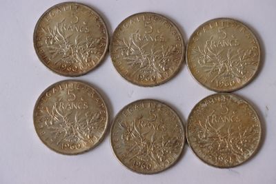 six pièces de monnaie britanniques empilées les unes sur les autres sur une surface blanche