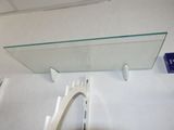 a glass shelf with a mirror above it on the wall