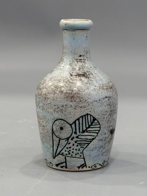 un petit vase orné d'un oiseau, posé sur une table