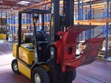 a forklift in a warehouse with pallets in the background