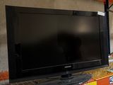 un téléviseur à écran plat posé sur une étagère dans un magasin