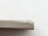 someone is holding a cigarette in their hand on a white surface