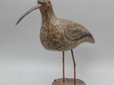 un petit oiseau posé sur un socle en bois