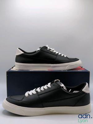 a pair of black and white sneakers sitting on top of a box