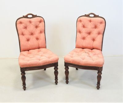 paire de fauteuils rembourrés roses avec des pieds et des accoudoirs en bois