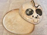 a cat shaped plate on the table with a tray underneath it