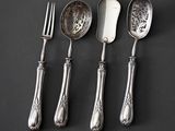 three spoons, a fork, and a knife on a table