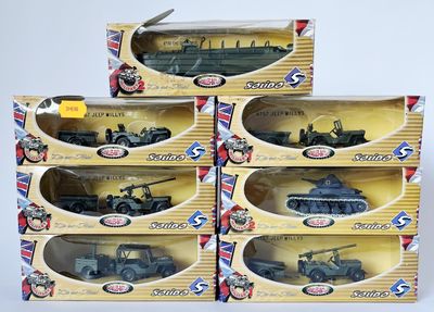 trois boîtes contenant des véhicules militaires miniatures, posées sur une surface blanche