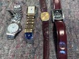 trois montres et une montre-bracelet sont posées sur une table
