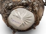 a silver ball with a tag on it on a white surface