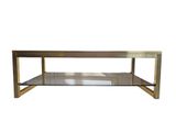 a brass coffee table with a glass shelf on top of it