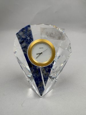 une horloge bleue et blanche posée sur un bloc de cristal