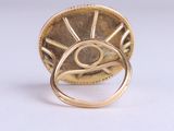 an image of a gold ring with an eye inside of it