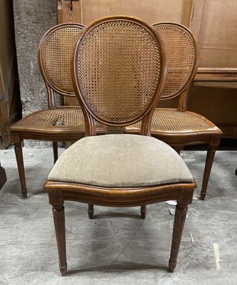 three chairs with cane back and cane back cushions in a room