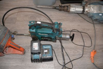 a drill and a hammer on a table next to a cell phone