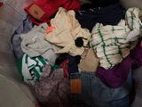 a pile of clothes sitting in a basket on the floor