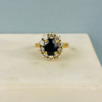 une bague en diamant noir et blanc posée sur un bloc de marbre