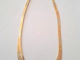 a gold necklace on a white background