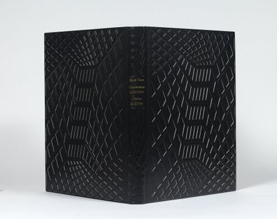 un livre noir posé sur une table blanche
