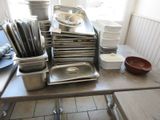 de nombreuses casseroles et poêles posées sur une table dans une cuisine