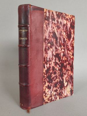 un vieux livre à la couverture rouge posé sur une table