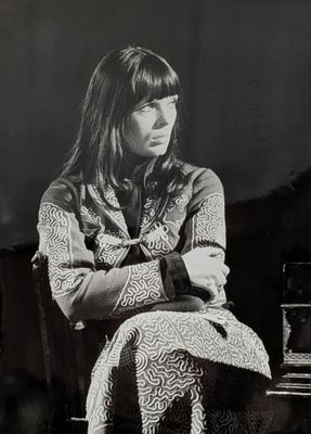 photographie en noir et blanc d'une femme assise sur un canapé à côté d'un verre de vin