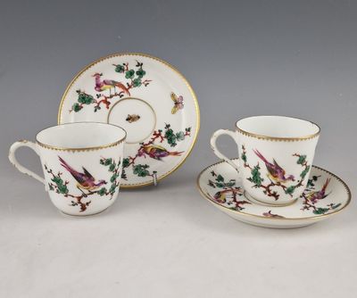 deux tasses et soucoupes ornées d'oiseaux, posées sur une table