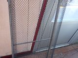 a large metal cage with a red handle on it