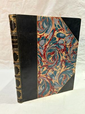 an old book sitting on top of a white table next to a white sheet