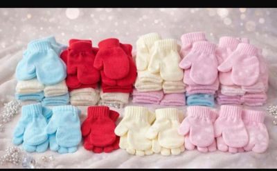 de nombreuses paires de moufles pour bébé posées sur une couverture