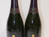 Deux bouteilles de vin sont posées l'une à côté de l'autre sur une table.