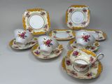 cinq tasses, deux soucoupes et une assiette sur la table