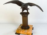 statue d'un aigle sur un socle, sur fond blanc