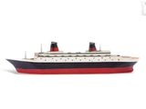une petite maquette de paquebot de croisière posée sur une surface blanche