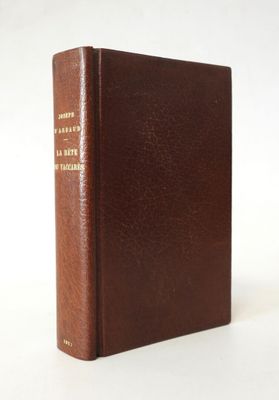 un vieux livre marron posé sur une table blanche