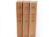 three books sitting on top of each other on a white surface