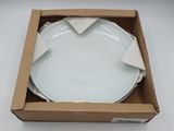 une assiette blanche dans une boîte posée sur une surface blanche