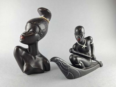 two figurines of a woman and a man sitting on a boat