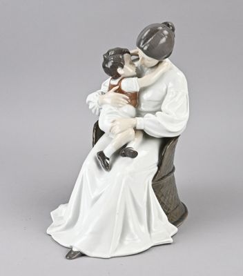 une figurine représentant une femme tenant un enfant sur ses genoux
