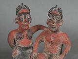two figurines of a man and a woman sitting next to each other