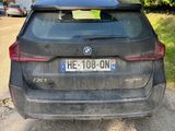 the back end of a black car parked on the side of a road