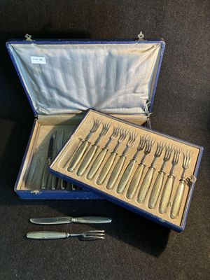 des couverts dans un étui bleu posé sur une table, contenant un couteau et une fourchette