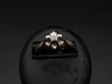 a close up of a diamond ring sitting on top of a black object
