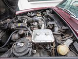 a red car with a engine in the trunk of it