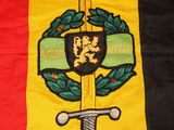 the flag of belgium is displayed on a bed with a sword