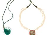 a close up of a necklace with beads and a tassel on a white background