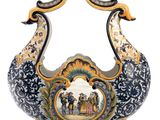 a decorative vase with a peacock on it on a stand