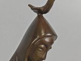 bronze statue of a woman with a bird on top of her head