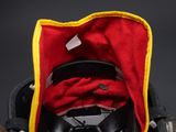 a red and yellow backpack with a red hat on it